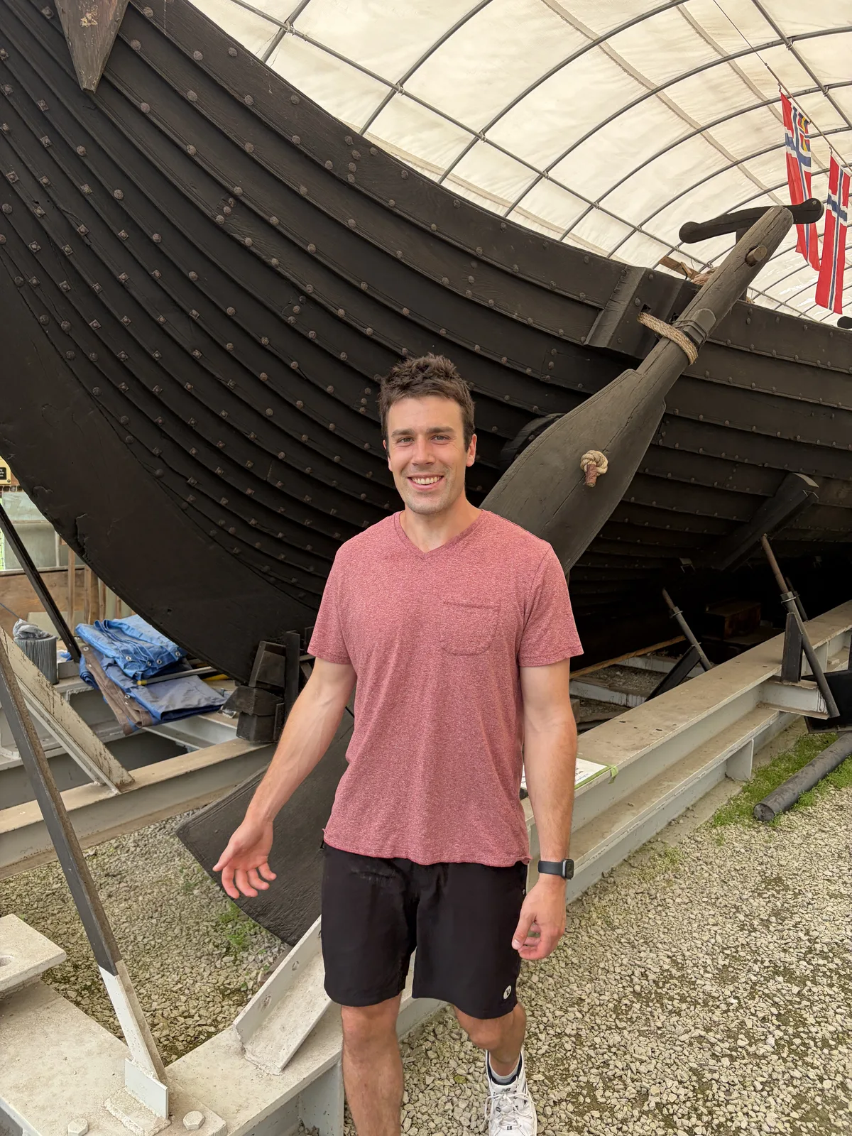 Cam standing beside a historic Viking ship in the Chicago suburbs